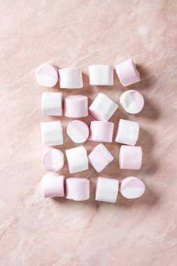 Satır pembe mermer arka plan üzerinde beyaz pembe büyük marshmallow. Düz lay, alan. Tatlı yiyecek ve içecek.