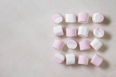 Satırının beyaz mermer zemin üzerine beyaz pembe büyük marshmallow. Düz lay, alan. Tatlı yiyecek ve içecek.