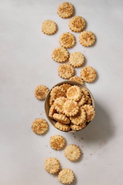 Ev yapımı Aperatif kurabiye peynir susam kurabiye kase beyaz mermer zemin üzerinde. Düz lay, uzay