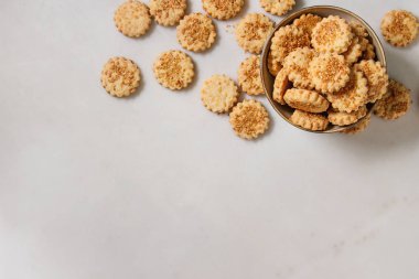 Ev yapımı Aperatif kurabiye peynir susam kurabiye kase beyaz mermer zemin üzerinde. Düz lay, uzay