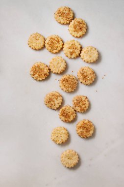 Ev yapımı Aperatif kurabiye peynirli susam çerezler beyaz mermer zemin üzerinde. Düz lay, uzay