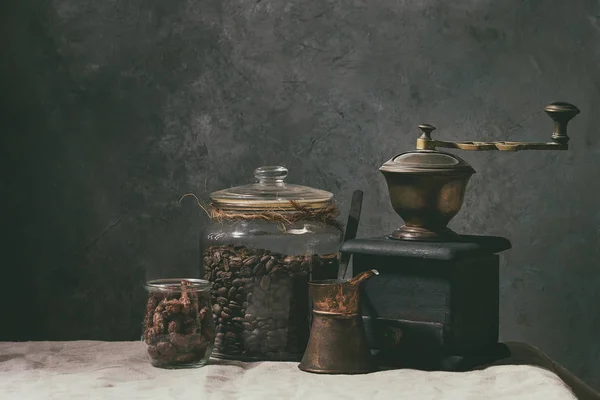 咖啡收藏 烤黑咖啡豆在罐子 老式咖啡研磨机 Jezve 甜加糖杏仁站在桌子上与亚麻桌布 — 图库照片