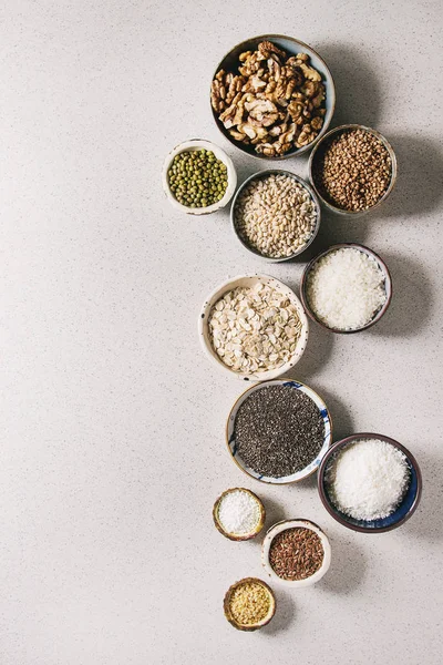 な生未調理の穀物の Superfood 穀物嘉 リネン クルミ タピオカ オートミール ココナッツ 米セラミック ボウル灰色の斑点を付けられた背景 — ストック写真