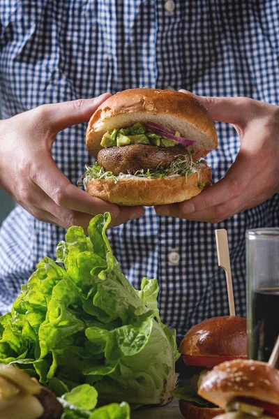 Człowiek Niebieską Koszulę Trzymając Rękach Domowych Weganinem Burger Pszenicy Bun — Zdjęcie stockowe