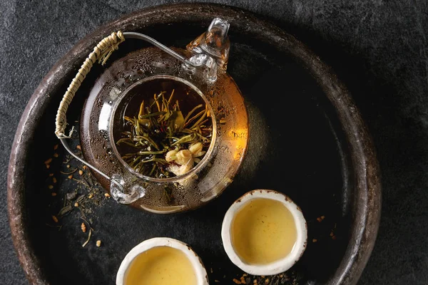热茶在两个传统的中国粘土陶瓷杯 并打开玻璃茶壶在托盘上的黑色大理石背景 — 图库照片