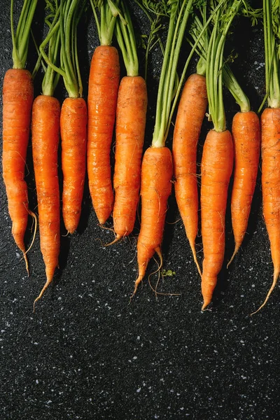 Морковь с вершинами в ряд — стоковое фото