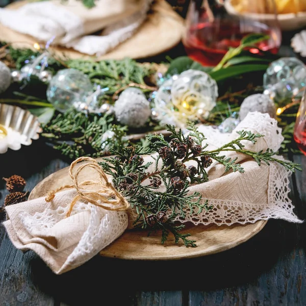 圣诞或新年餐桌设置与空陶瓷盘 餐巾纸 圣诞Thuja花环 明亮的花环和点燃蜡烛在黑暗的木制木板桌上 假日气氛 — 图库照片