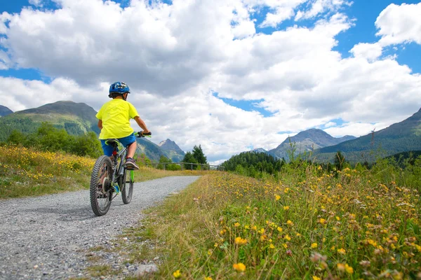 Criança em uma bicicleta em uma estrada de natureza — Fotografia de Stock