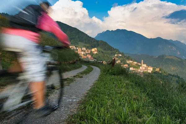 Efeito Borrão de uma bicicleta de montanha em uma estrada de terra em direção ao pequeno — Fotografia de Stock