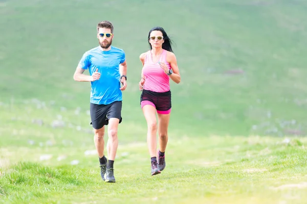 La acción de los corredores en los prados montañosos en verano. Hombre y mujer — Foto de Stock