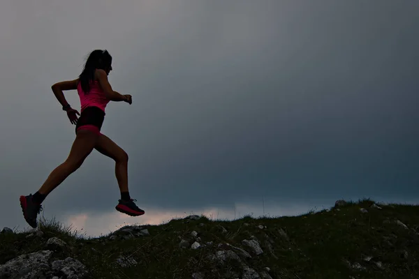 Chica deportiva con hermoso cuerpo atlético corre en la cresta alpina — Foto de Stock