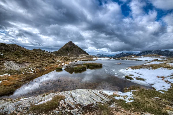 イタリアアルプスの最初の雪と小さな高山湖 — ストック写真