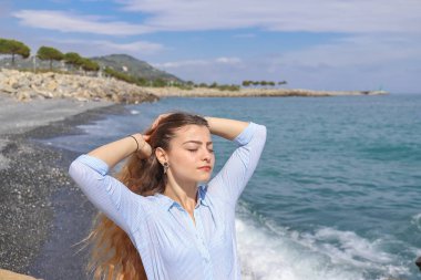 Riva al mare içinde Ritratto di una giovane ragazza con i capelli al vento.