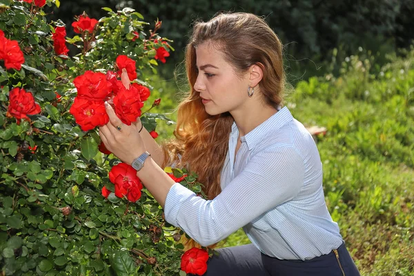Ragazza che ammira le gül una bella giornata soleggiata.