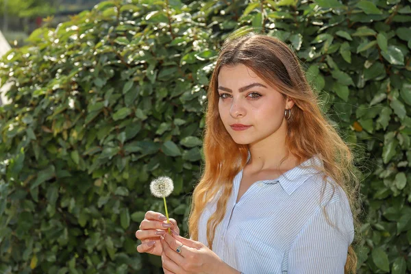 Ritratto di una ragazza con soffione fiore içinde mano