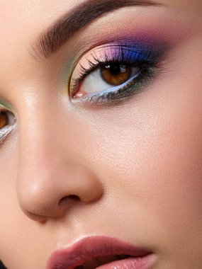 Moda makyaj mavi küpeler ile güzel bir kadın portresi. Modern moda makyaj. Çok renkli dumanlı gözler. Stüdyo vurdu