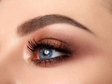 Kırmızı ve turuncu tonları dumanlı gözler makyaj ile güzel kahverengi ile mavi kadın göz kapatın. Modern moda makyaj.