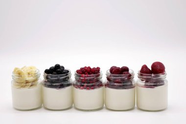 Yoğurtlu kavanoza taze çilek. Beyaz arka plan üzerinde.