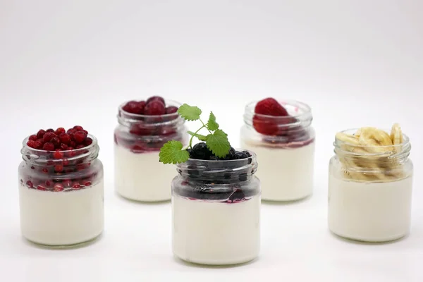 Verse bessen in de pot met de yoghurt. Op witte achtergrond. — Stockfoto