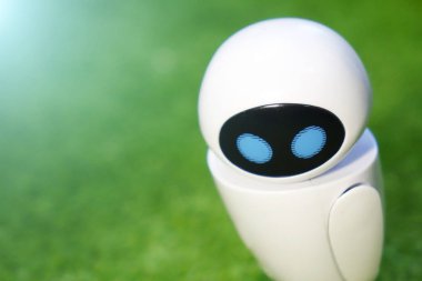 Küçük bir robot izole bir yeşil zemin üzerine insansı bir gövdeye sahip. Yapay zeka-Ai. Mavi-beyaz robot.