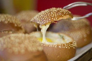 Sıvı yumurta, domuz pastırması ve eritilmiş peynir ile buns. Yumurta, peynir ve domuz pastırması sandviç. Sıcak kahvaltı.