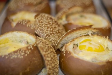 Sıvı yumurta, domuz pastırması ve eritilmiş peynir ile buns. Yumurta, peynir ve domuz pastırması sandviç. Sıcak kahvaltı.