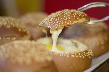 Sıvı yumurta, domuz pastırması ve eritilmiş peynir ile buns. Yumurta, peynir ve domuz pastırması sandviç. Sıcak kahvaltı.