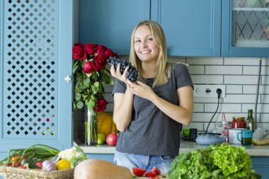 Kız mutfakta sebze ile sağlıklı yiyecek hazırlanıyor. Vejetaryen mutfağı. Onun yirmili genç bir beyaz. Sağlıklı beslenme kavramı.