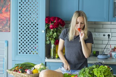 Kız mutfakta sebze ile sağlıklı yiyecek hazırlanıyor. Vejetaryen mutfağı. Onun yirmili genç bir beyaz. Sağlıklı beslenme kavramı.
