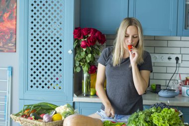 Kız mutfakta sebze ile sağlıklı yiyecek hazırlanıyor. Vejetaryen mutfağı. Onun yirmili genç bir beyaz. Sağlıklı beslenme kavramı.