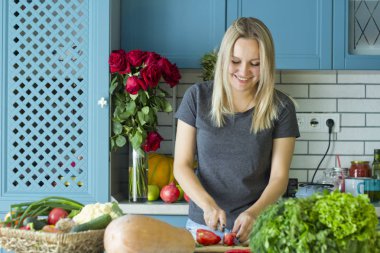 Kız mutfakta sebze ile sağlıklı yiyecek hazırlanıyor. Vejetaryen mutfağı. Onun yirmili genç bir beyaz. Sağlıklı beslenme kavramı.