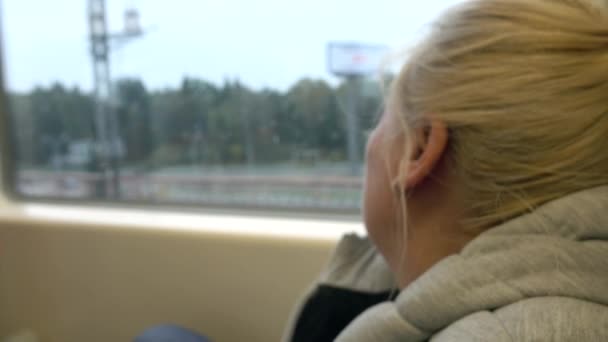 Женщина едет на поезде и смотрит в окно. Концепция туризма и путешествия — стоковое видео
