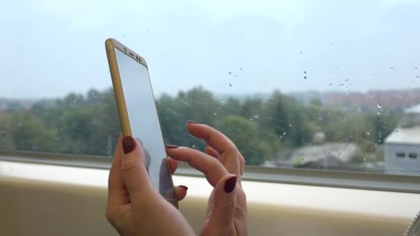 Een vrouw rijdt een trein, schrijft een bericht op een mobiele telefoon. — Stockvideo