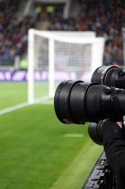 Bir futbol sahası arka plan üzerinde kamera objektifi.