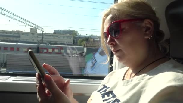 列車で旅行の女性観光客。ニュースを読んで、スマート フォンを探している女性. — ストック動画