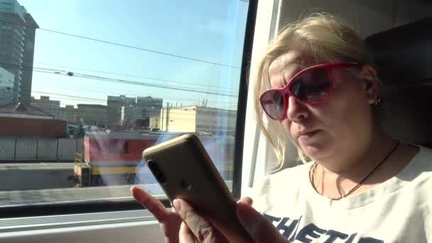 Turista viajando en tren. Mujer mirando el teléfono inteligente, leyendo las noticias . — Vídeo de stock