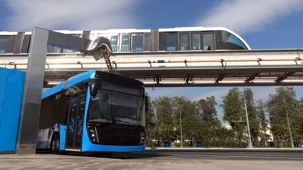 Mavi elektrikli otobüs şarj istasyonu. Monoray üzerinde modern trenler.