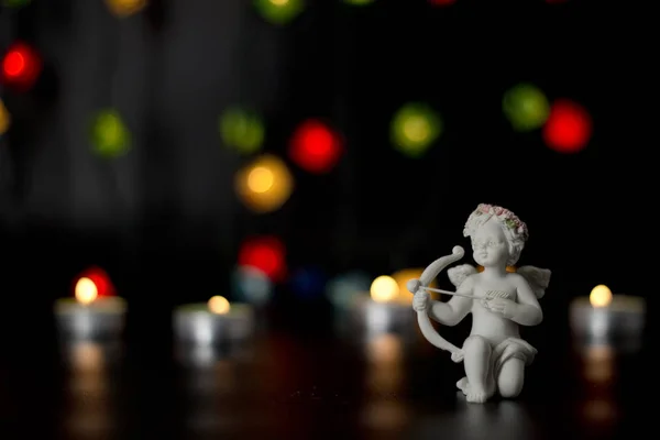カラフルなライト ガーランド、ボケ味の背景に白い天使. — ストック写真