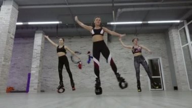 Bir grup, üç genç, seksi kız Kangoo spor salonunda atlar..