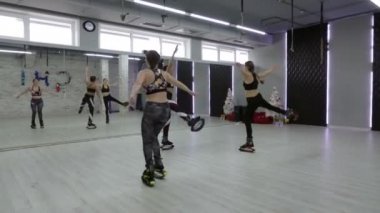 Bir grup, üç genç, seksi kız Kangoo spor salonunda atlar..