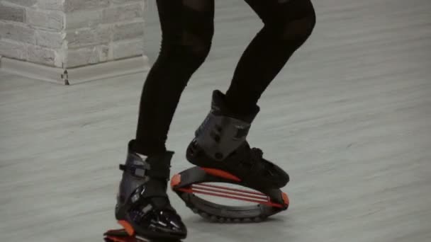 Close-up van sportieve meisje Kangoo jumps. Sportschoenen. — Stockvideo