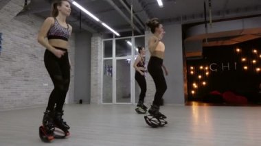 Bir grup, üç genç, seksi kız Kangoo spor salonunda atlar..