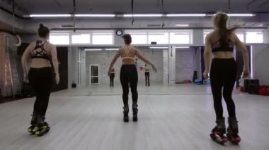 Bir grup, üç genç, seksi kız Kangoo spor salonunda atlar..