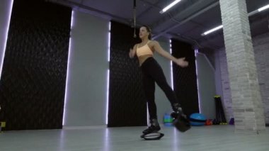 Genç, seksi kız Kangoo spor salonunda atlar..