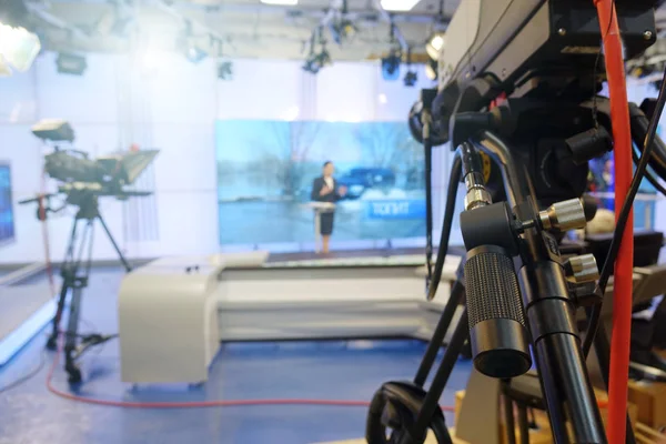 The news presenter reads the text on the teleprompter.Camera in the office. TV studio.