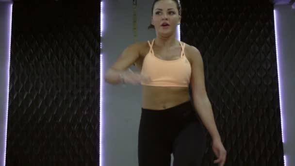 年轻, 性感的女孩袋鼠跳在健身房. — 图库视频影像