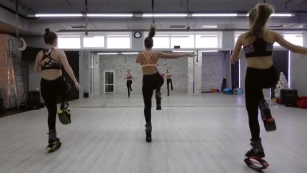 Un groupe féminin de trois jeunes filles sexy Kangoo saute dans la salle de gym . — Video