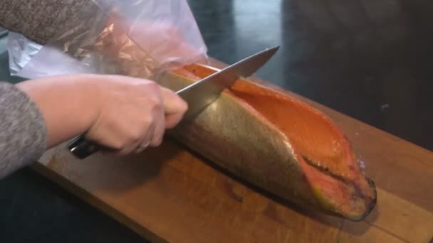 Cortar peixe marinho. Delicatessen. Frutos do mar.O peixe é cortado em uma tábua de corte . — Vídeo de Stock