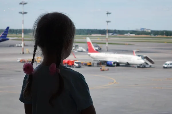 Junge Frauensilhouette am Flughafen. Das Flugzeug ist im Hintergrund. das Konzept des Lufttransports. — Stockfoto