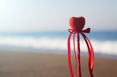 Sevgililer günü tebrik kartı kavramı, kırmızı kalp bozulmamış kumsalı, balayı tatil arka plan üzerinde.